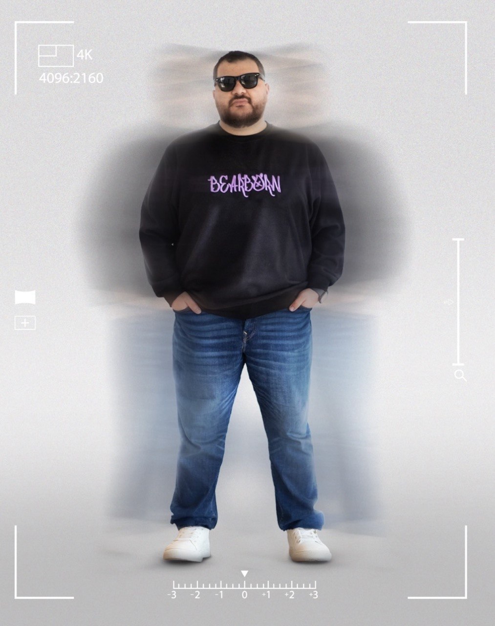 A model in the black Bearborn sweatshirt and sunglasses, standing against a studio backdrop